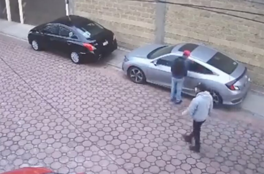 Revelan video cuando un sujeto enfrenta a dos ladrones que intentaban llevarse su vehículo a las afueras de un domicilio en Puebla